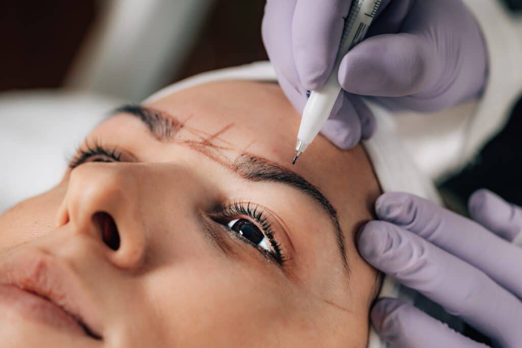 6 ways to update your beauty routine 4 close up of beautician doing permanent brow tattoo